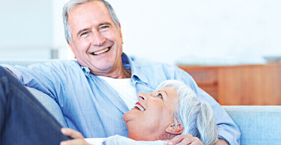 IDEAL UnfallRente: glückliches Rentenehepaar auf der Couch